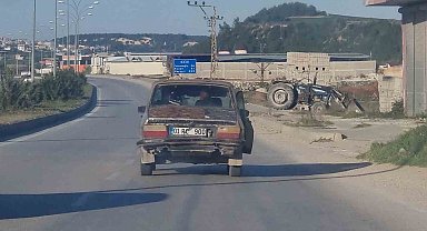 Kapısı açık halde seyreden eski otomobilin trafikte tehlikeli yolculuğu